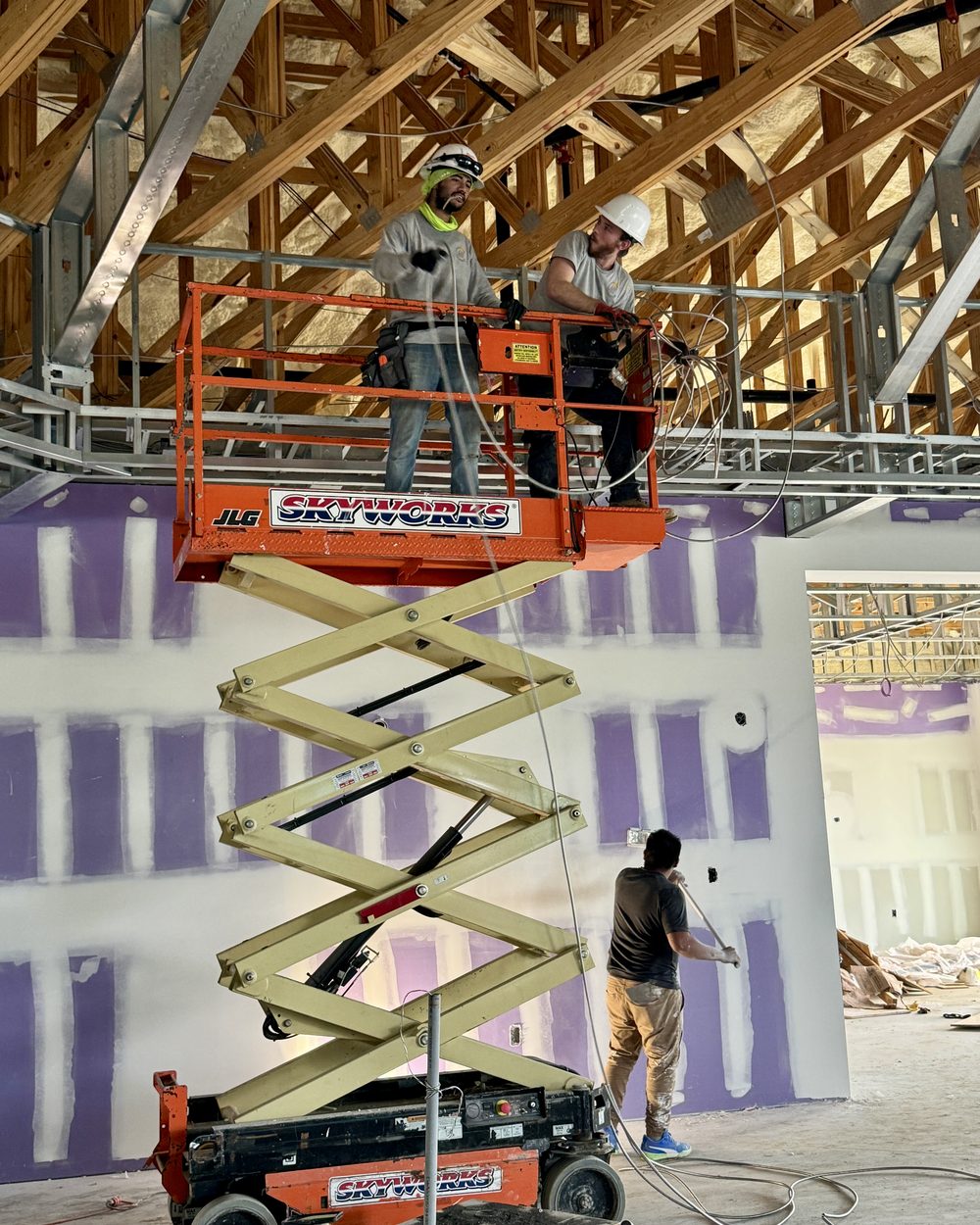 A Nova Electrical Contractors electrician working overhead from a scissor lift